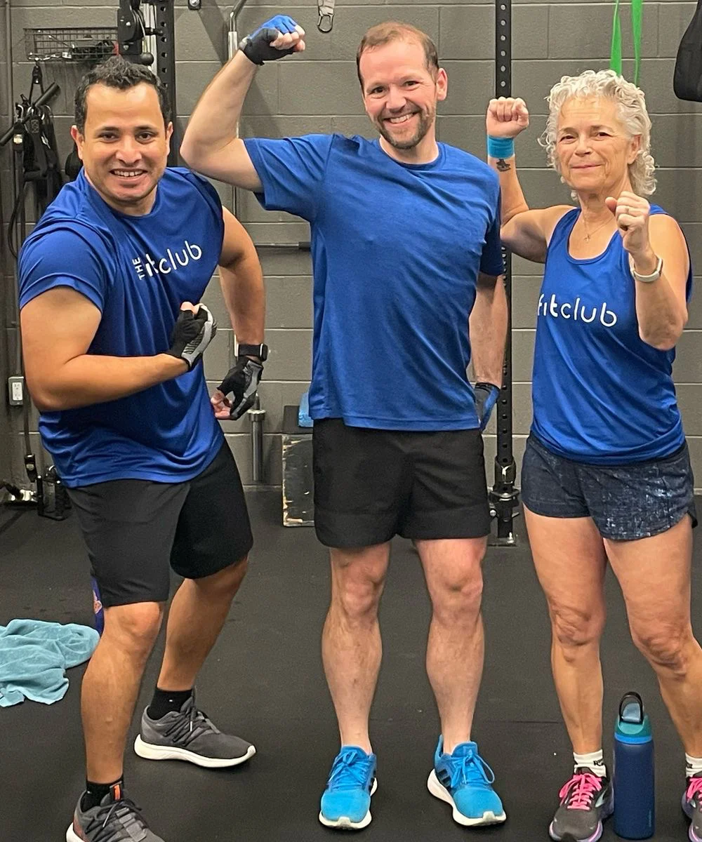 Five members pose for a photograph during a group fitness class