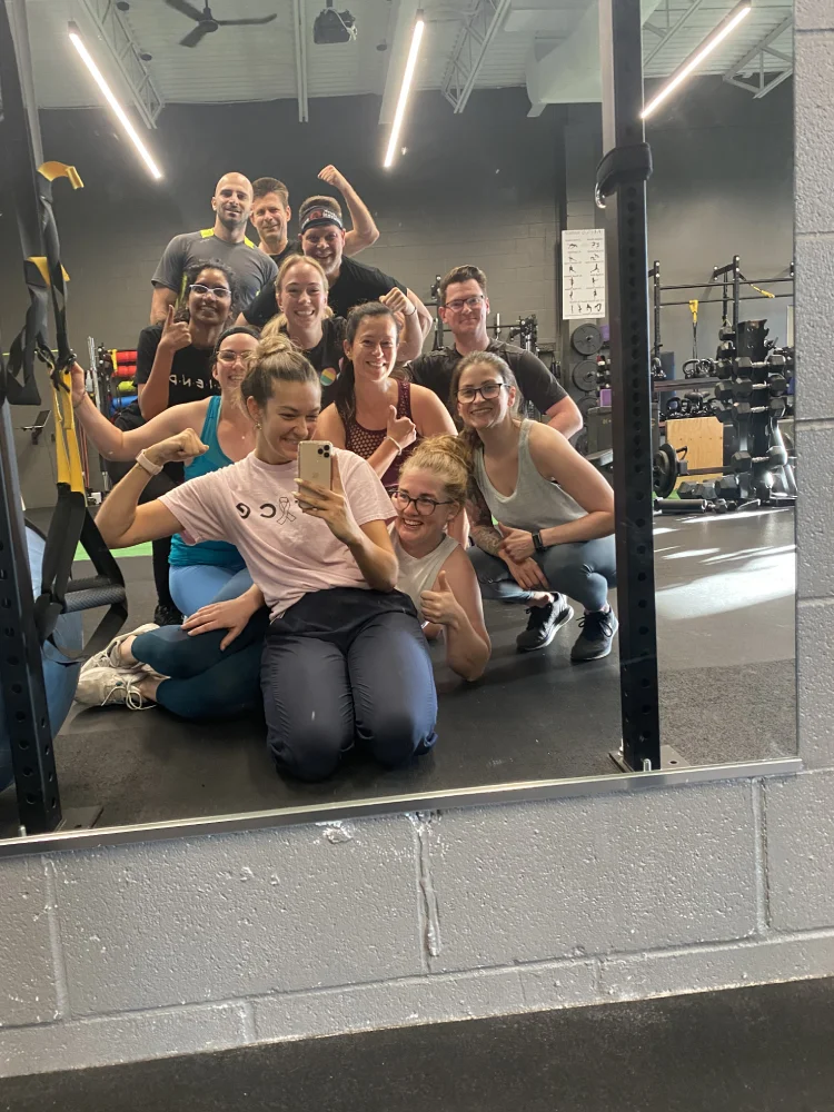 Group Fitness Class Mirror Selfie Trainer takes a mirror selfie with group fitness class members