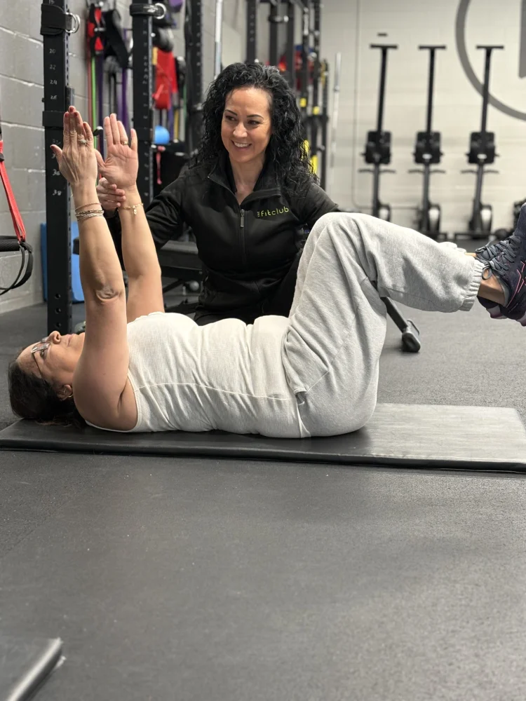 Personal Training Abdominal Exercise Female Fit Coach oversees woman performing an abdominal exercise